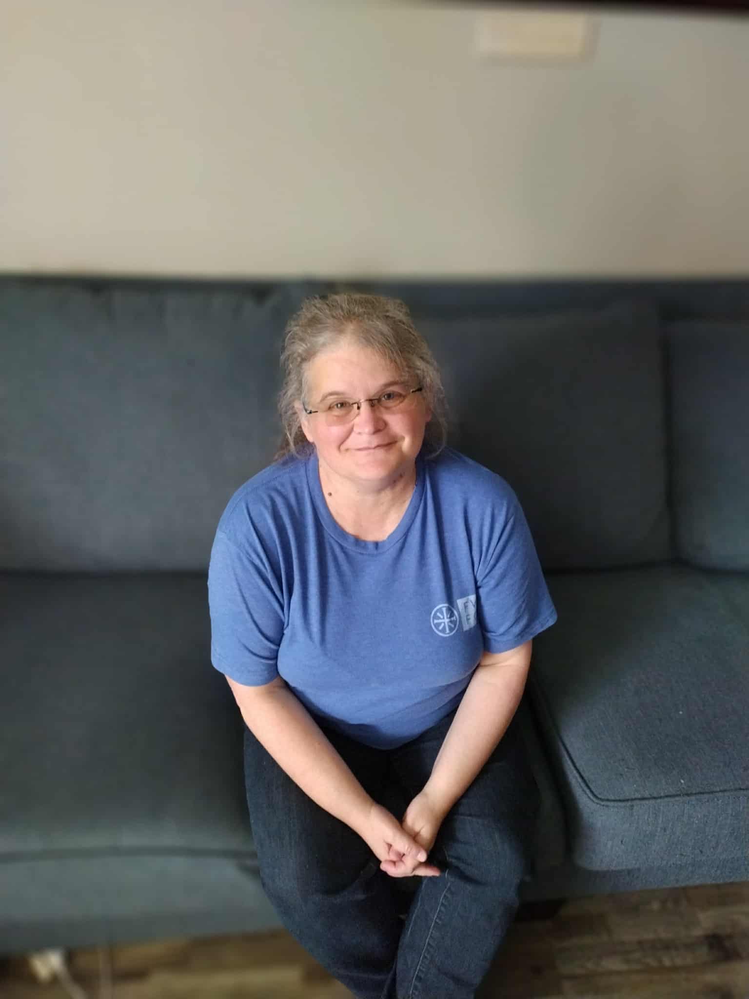 Christine smiling with handmade crochet items